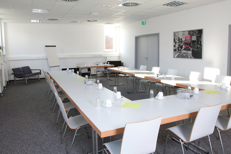 Bestuhlter Konferenzraum, eingedeckt mit Kaffeetassen