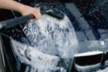 Lack des schwarzen BMWs wird mit Schaumbürste gewaschen.